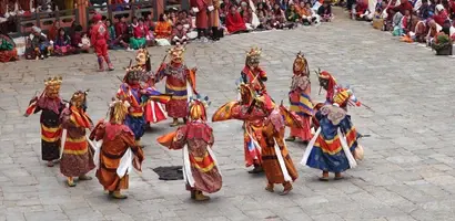 gouden-en-rode-dansers-op-stenen-plein &middot; bhutan-himalaya-trek
