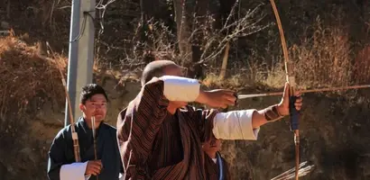 traditionele-boogschieten-tegen-oude-stenen-muur &middot; bhutan-himalaya-trek