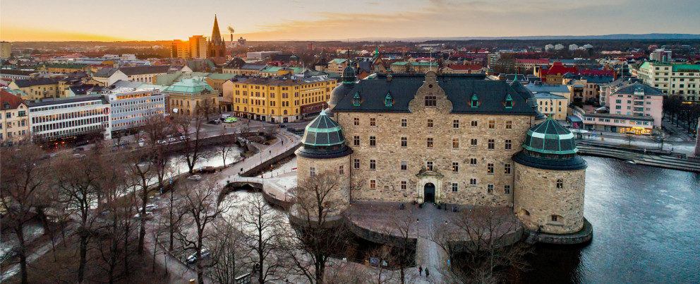 Vyn över Örebro slott i bakgrunden och Svartån i förgrunden och Olaus Petri kyrka i bakgrunden.