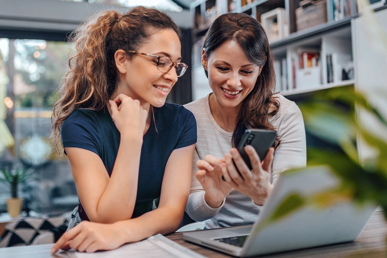 Zwei Frauen schauen gemeinsam auf ein Handy