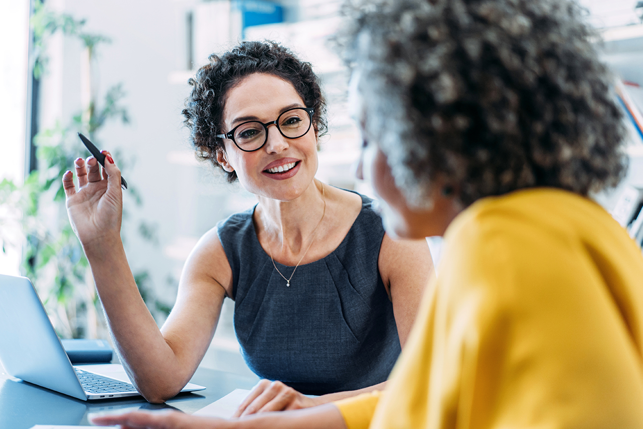 Zwei Frauen diskutieren über Firmengeld-Anlagen