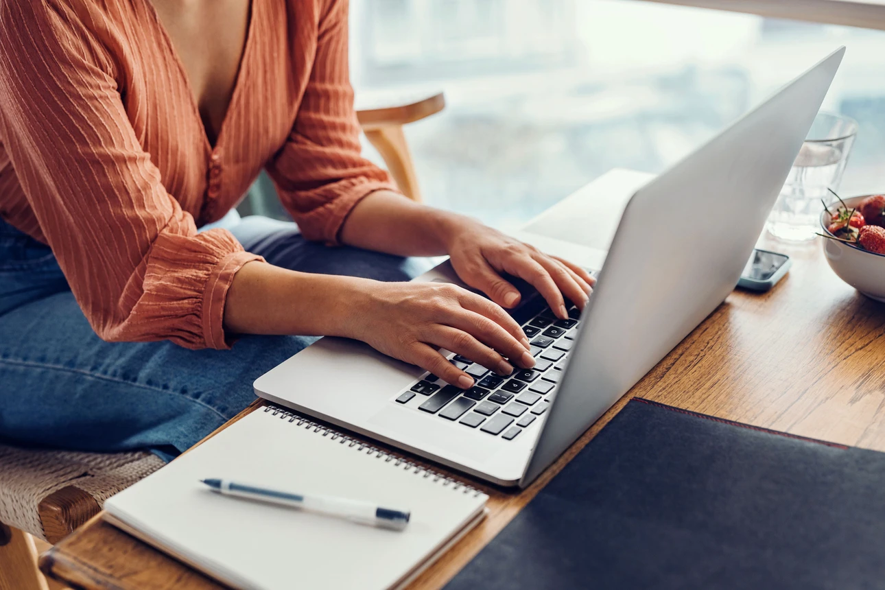 Eine Person tippt eine Nachricht in ihr Notebook