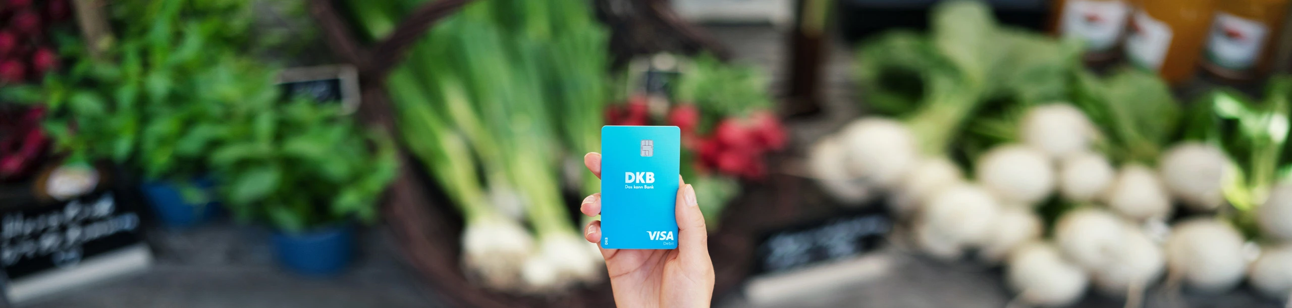Eine Person hält eine Visa Debitkarte in der Hand