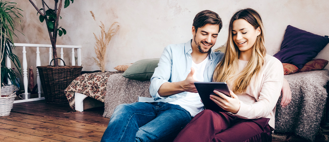 Ein Mann und eine Frau schauen auf ein Tablet