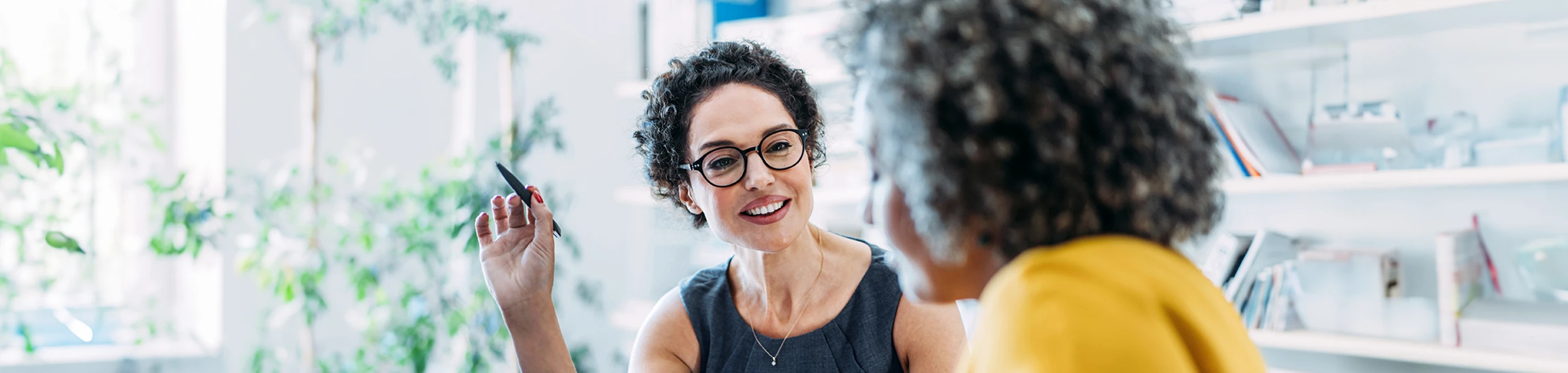 Zwei Frauen diskutieren über Firmengeld-Anlagen