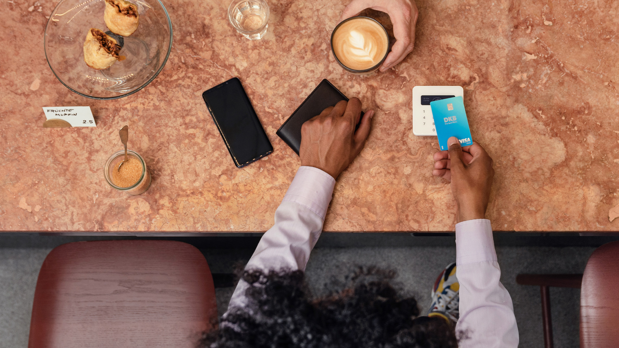 Kreditkarte und Bargeld liegen nebeneinander auf einem Restaurant-Tisch neben der Rechnung.