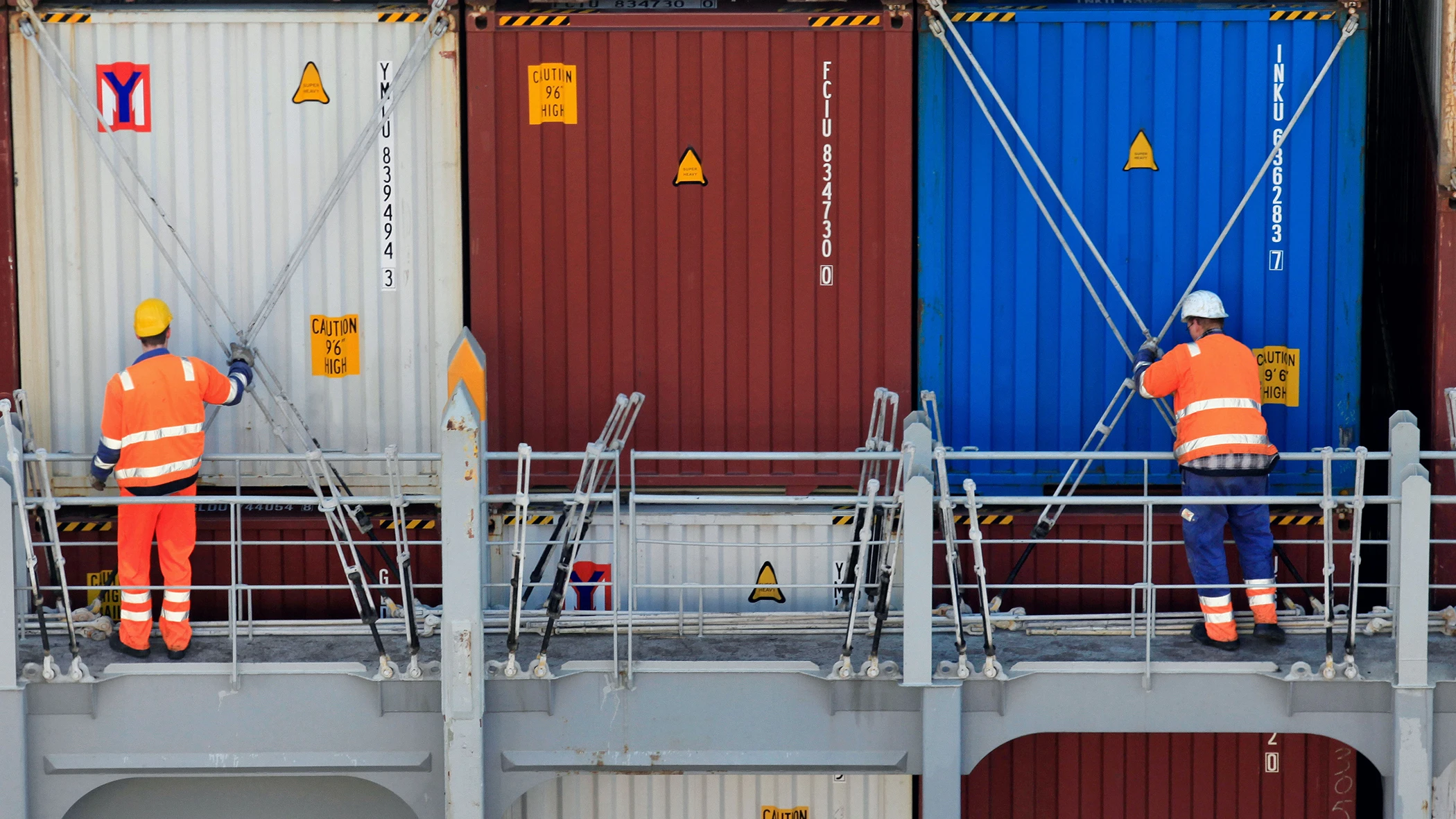 Zwei Arbeiter kontrollieren Frachtcontainer.