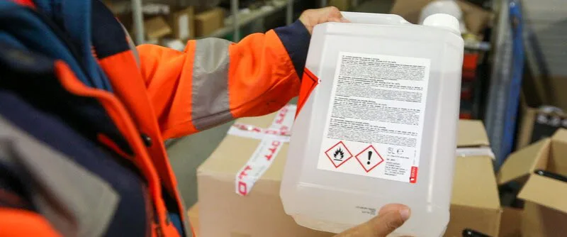 Un compagnon regarde l'étiquette d'un produit chimique
