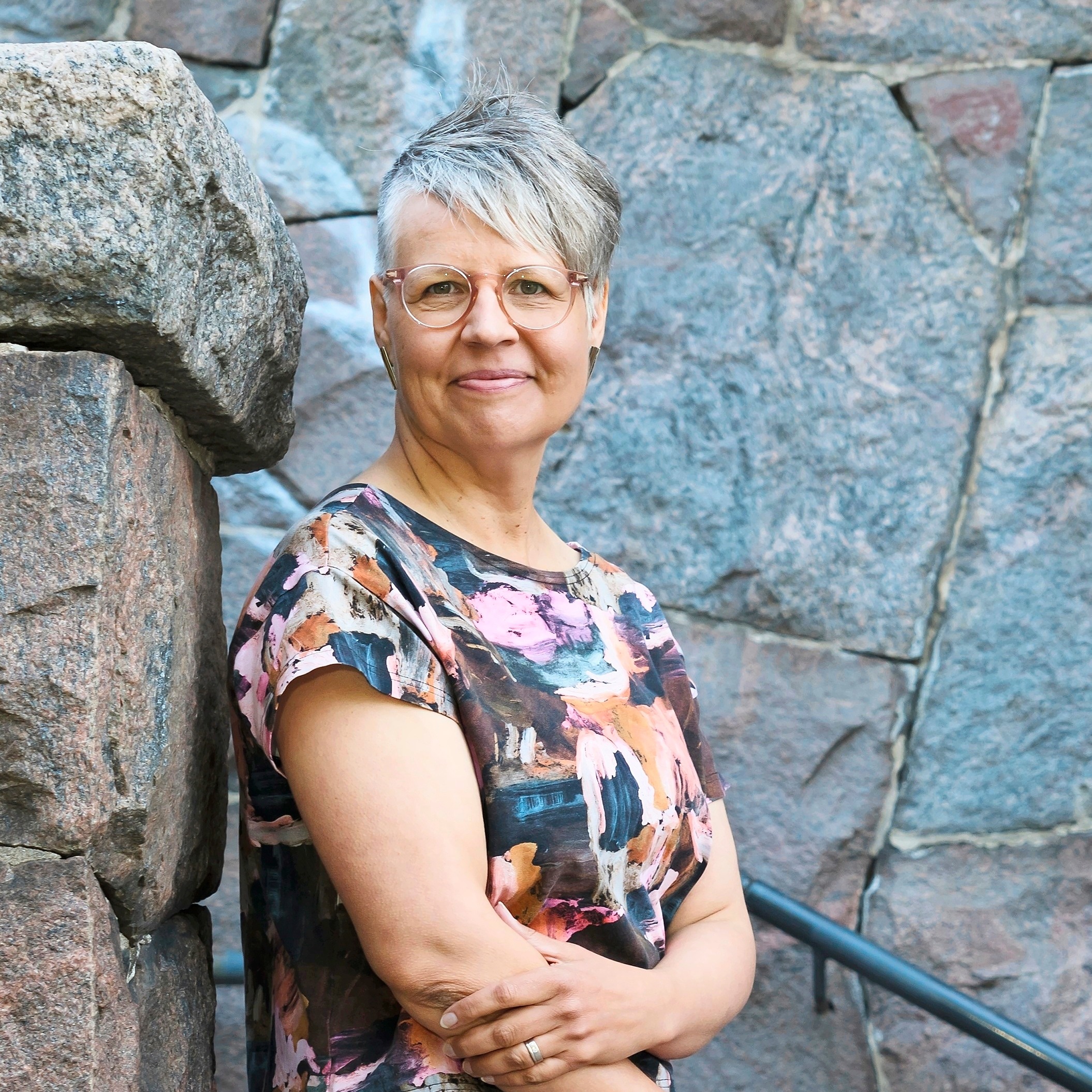 Virpi nojaa kiviseinään