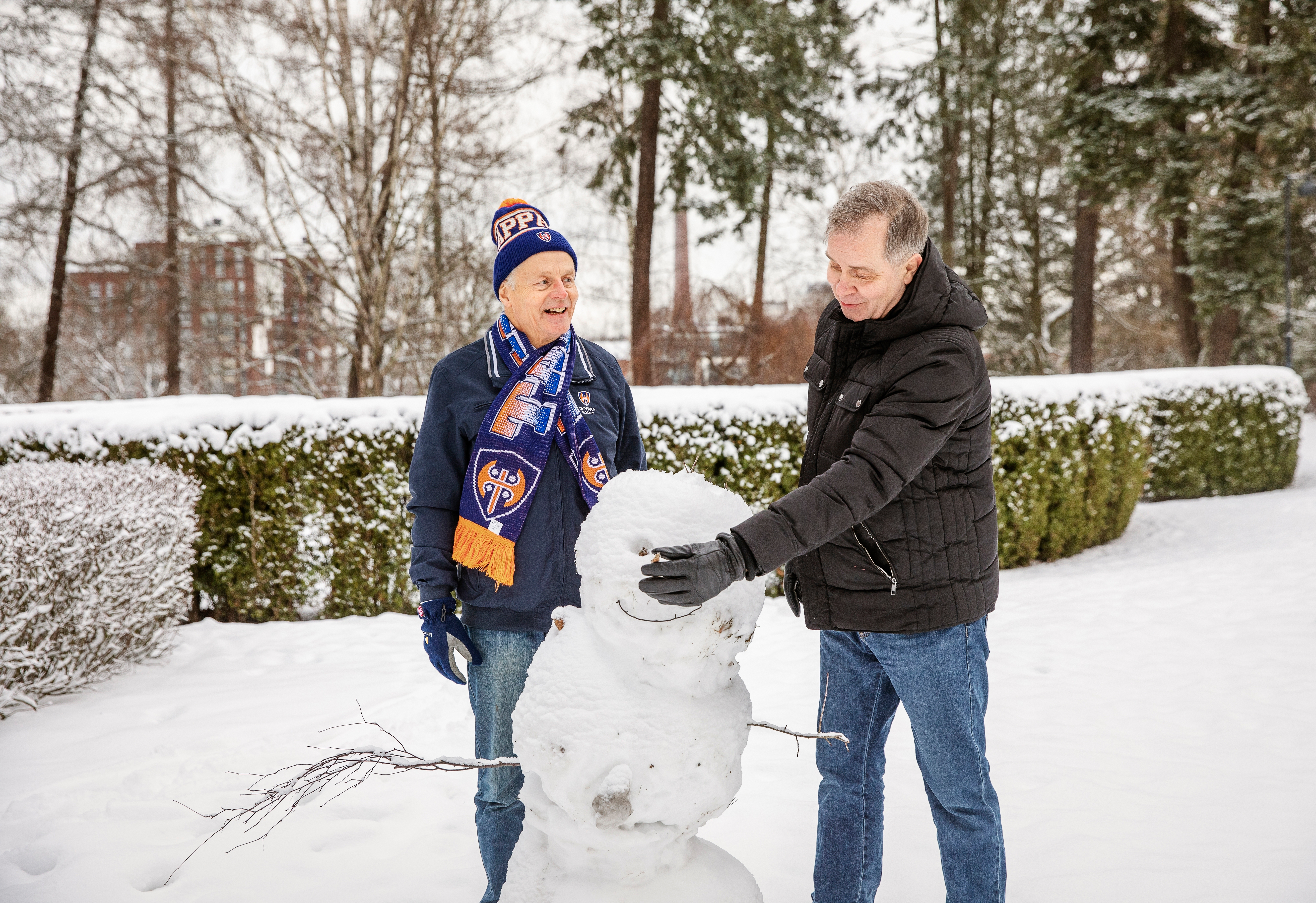Ystävykset rakentavat lumiukkoa