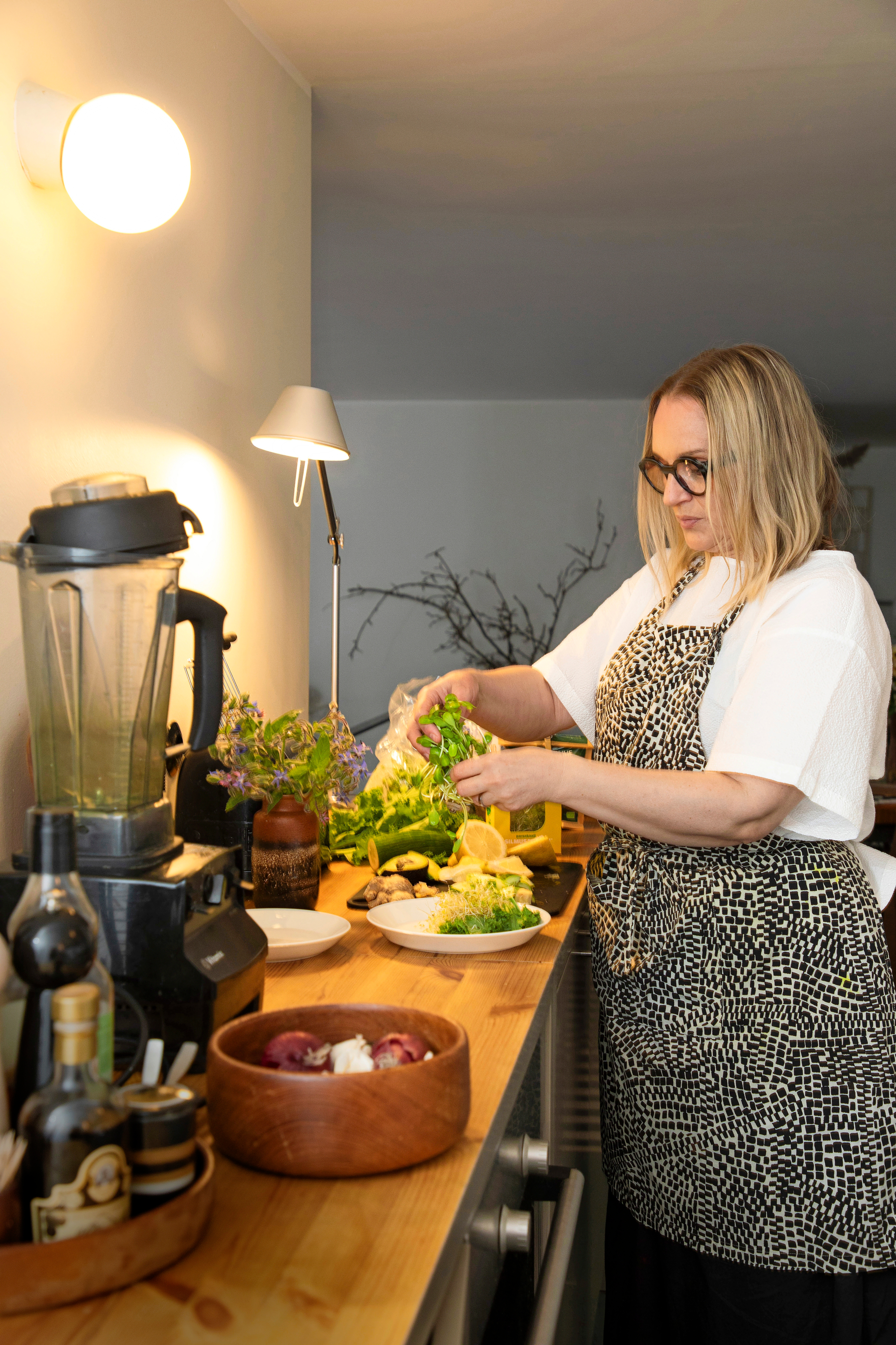 Helena Hietanen kotikeittiössään tekemässä kasvisruokaa