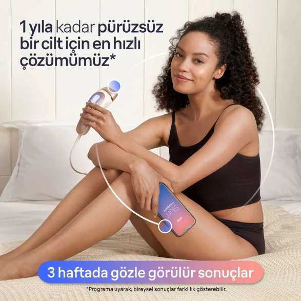 Kadın, sol elinde IPL cihazı ve sağ elinde cep telefonu ile yatakta oturuyor. Cep telefonunun ekranında Skin i·expert uygulaması gösteriliyor.