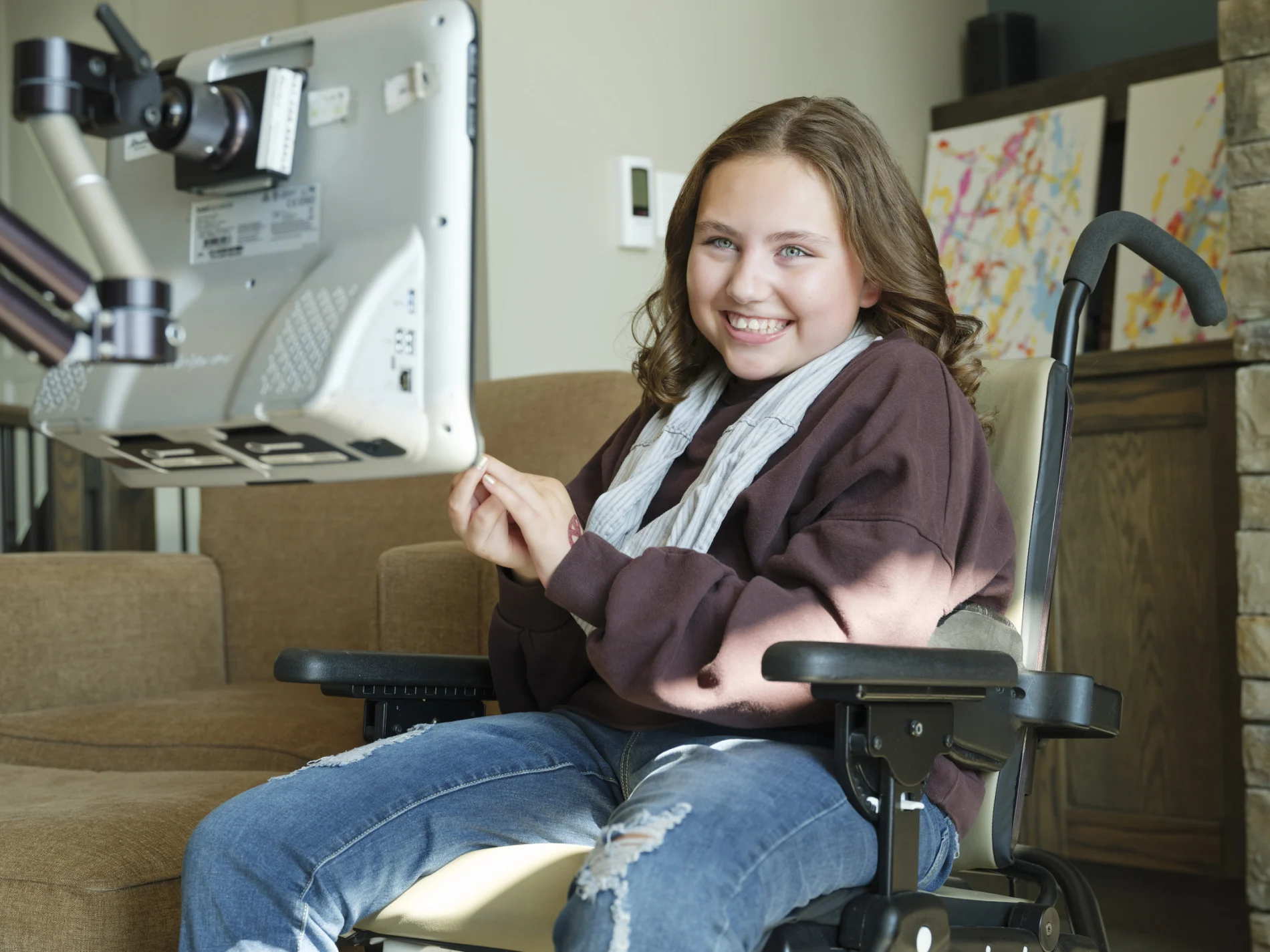 Olivia smiling in her wheelchair while using brain computer interface technology.