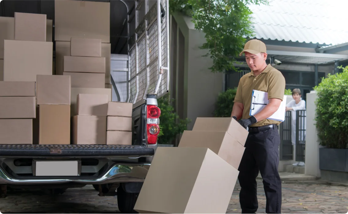 A delivery man devlivering boxes on a hand trolly