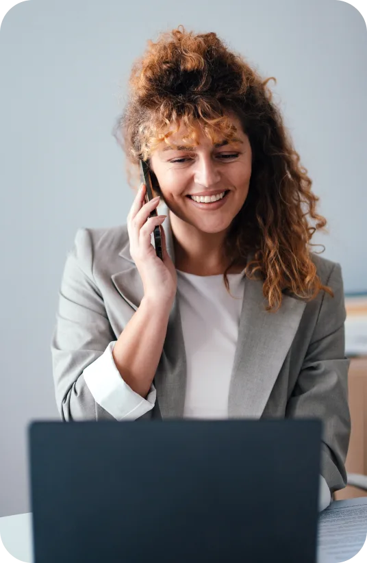 Businesswoman on phone call while working on laptop