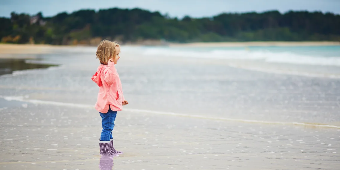 Une enfant sur la plage qui regarde la mer