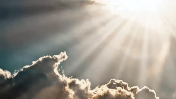 The Sun’s rays shine down through the clouds.
