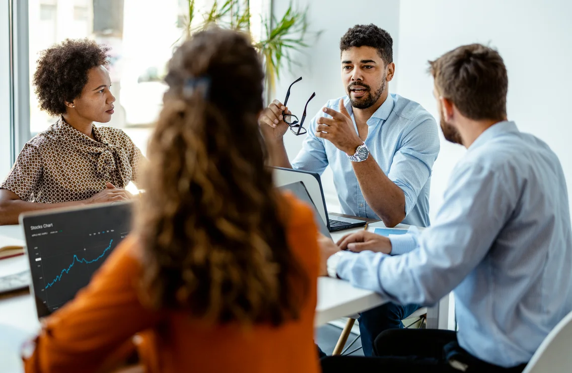 Groupe de collègues discutant dans un bureau.