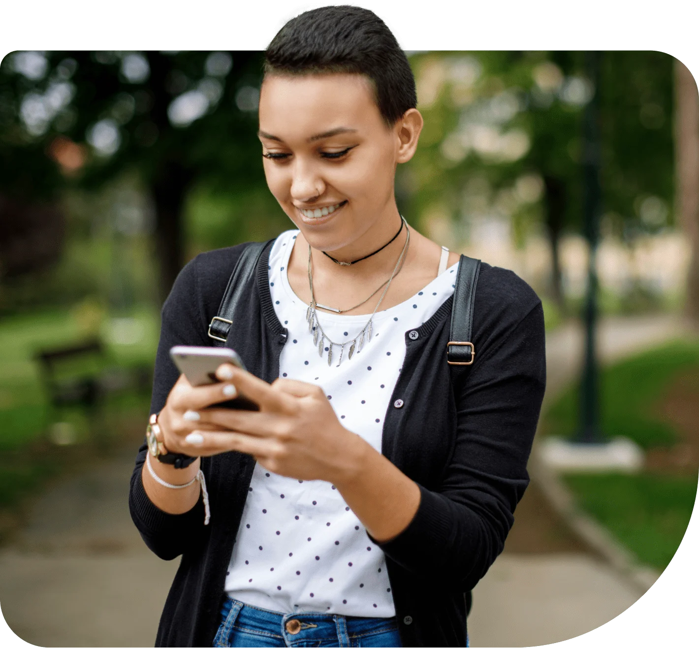 Une jeune adulte souriante clavarde avec des amis sur le téléphone intelligent qu’elle a reçu dans le cadre du programme Mobilité pour l’avenir.