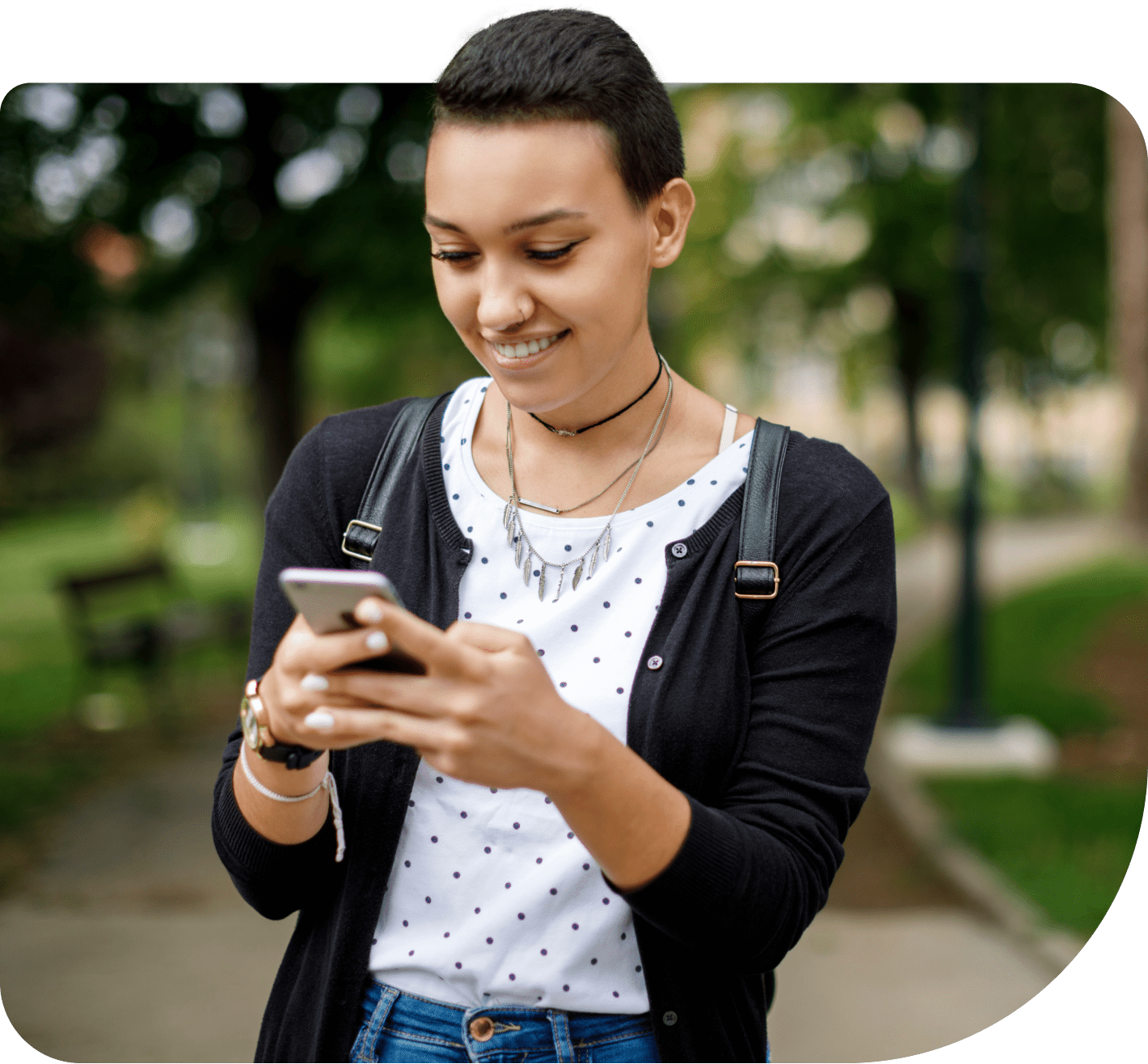 A young adult smiling as she connects with friends on a smartphone she received through the Mobility for Good program.