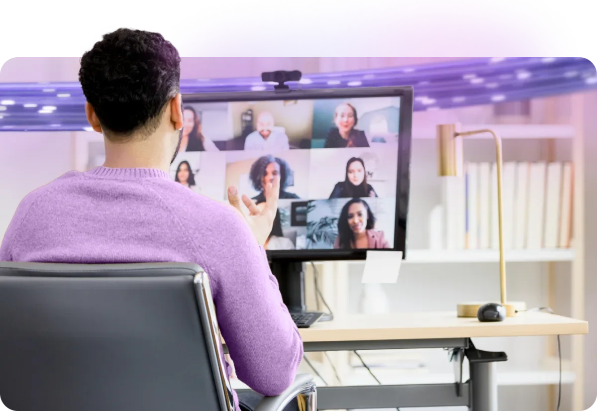 A person looks at a computer monitor and enjoys the crystal clear audio and video of his 5-gigabit-powered group video conference.