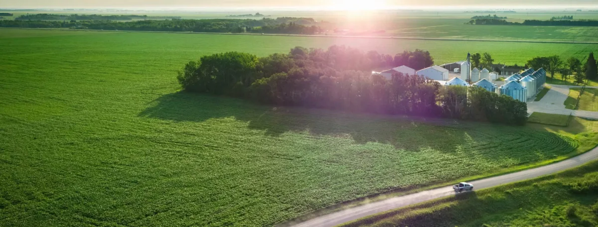 Une photo aérienne d’un domaine agricole entouré de champs verts.