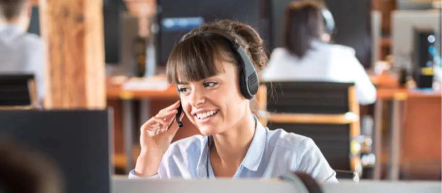 Woman talking on her headphone in front of a computer