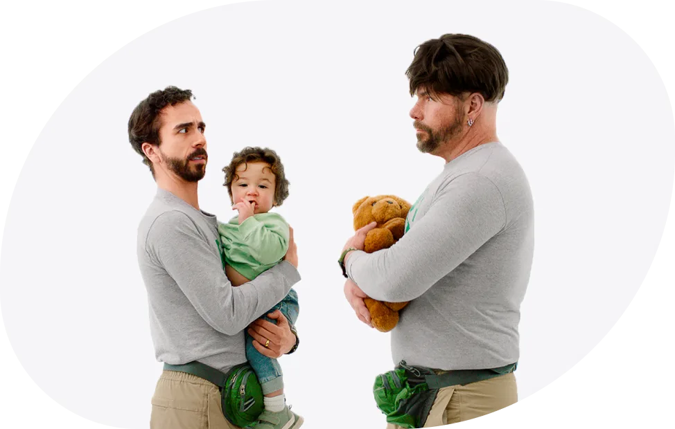 A person holding a baby and looking shocked at someone impersonating them, holding a stuffed animal.