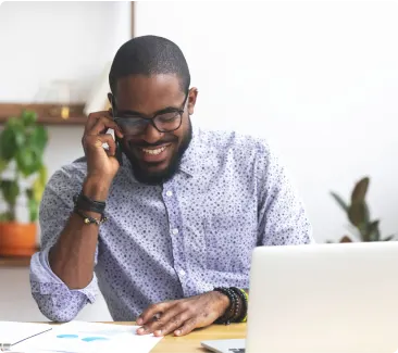 A man at his desk chatting on his smartphone