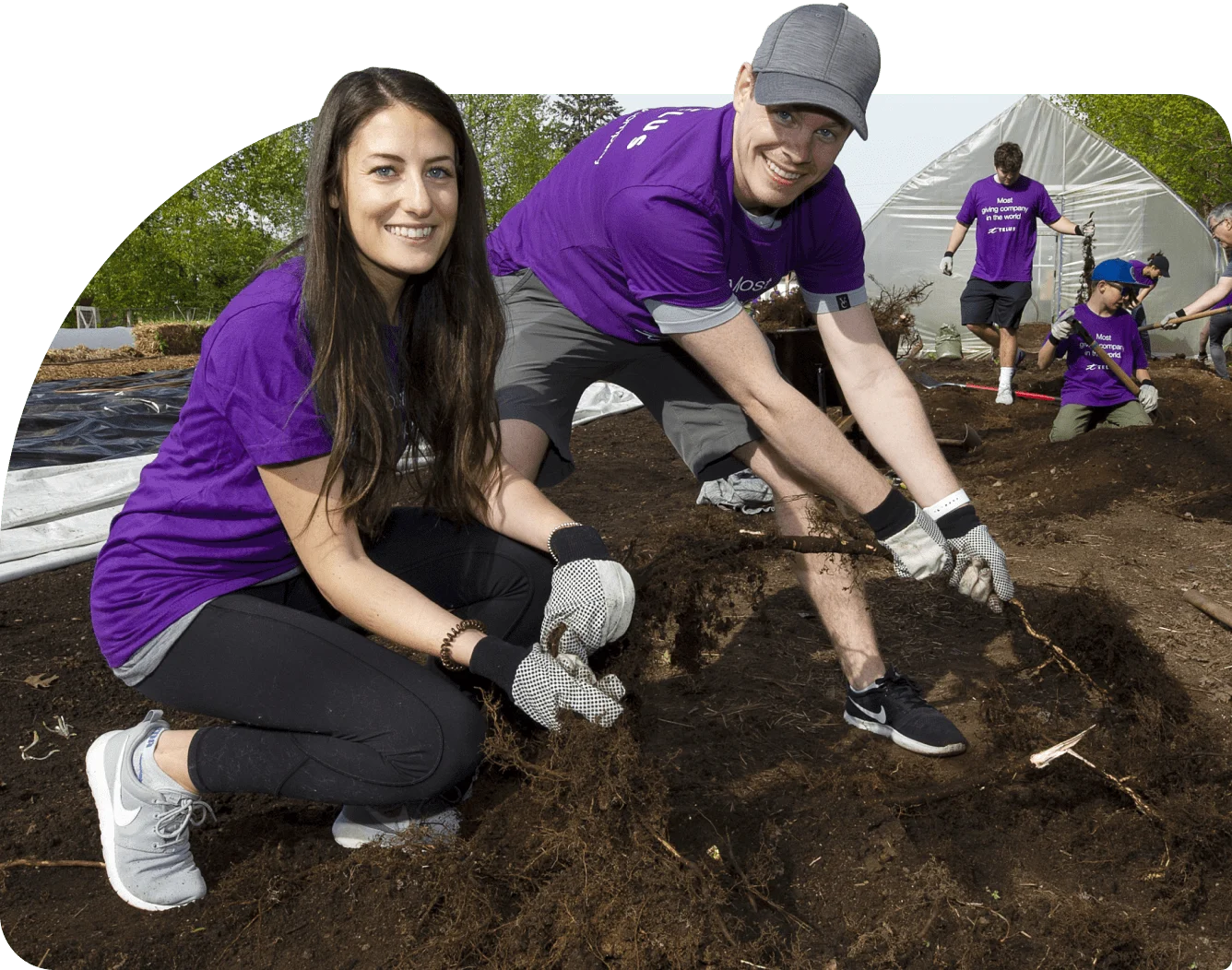 Des membres de l’équipe TELUS arrachent les mauvaises herbes d’une parcelle de terre dans un jardin communautaire.