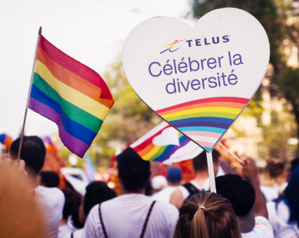 Un panneau TELUS célébrant la diversité lors d'un défilé de la fierté