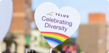 A TELUS Celebrating Diversity sign in a Pride parade