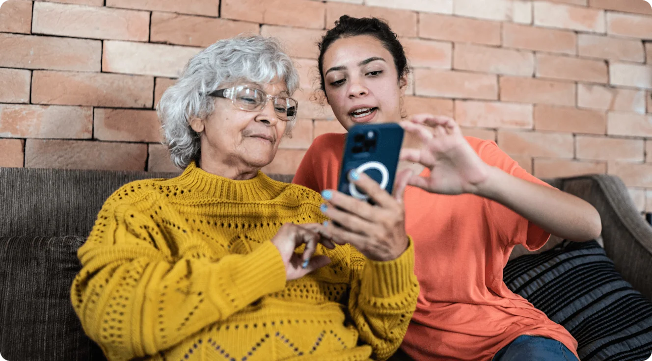 A younger woman and older woman viewing a smartphone together