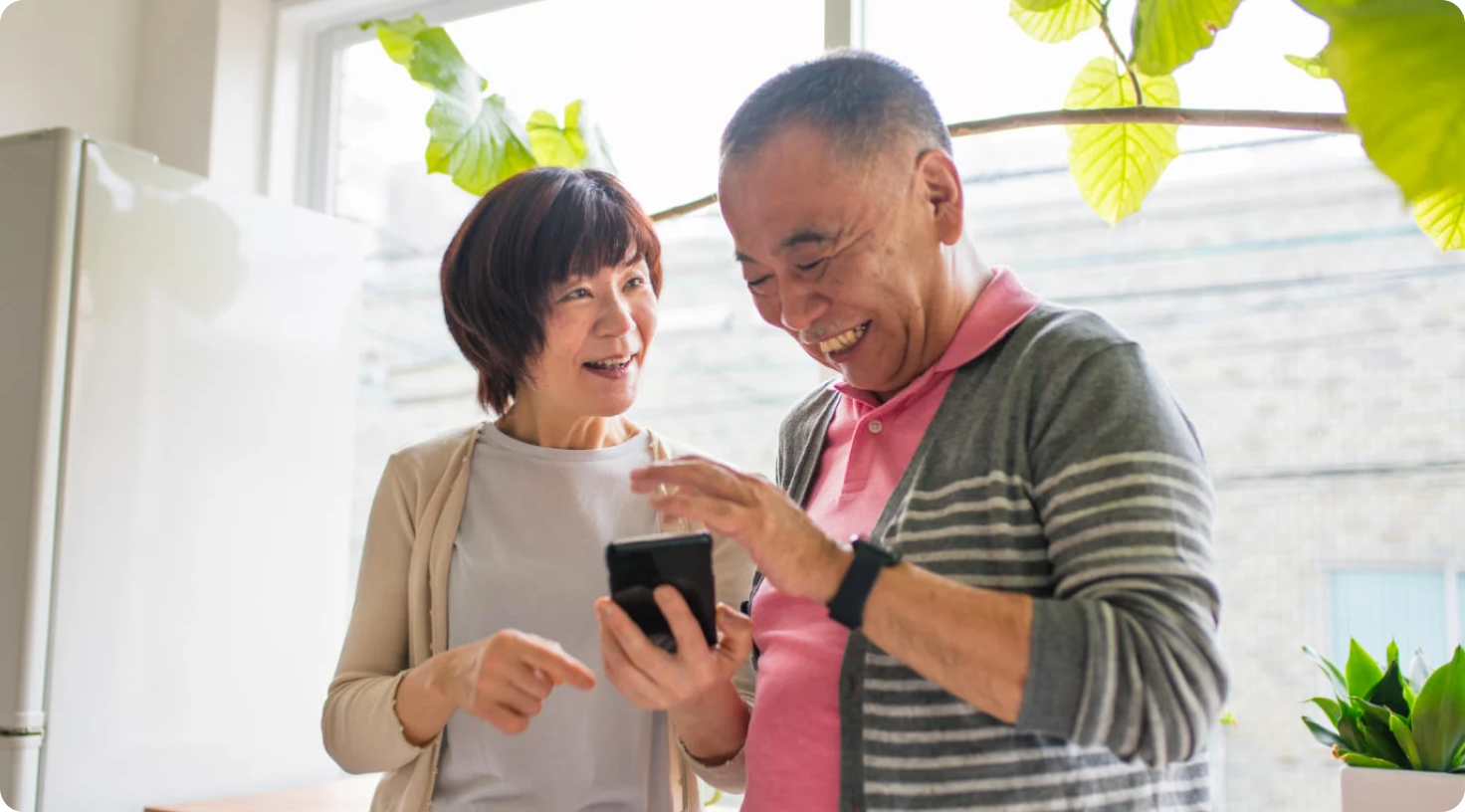 A senior couple sharing a laugh while viewing a smartphone