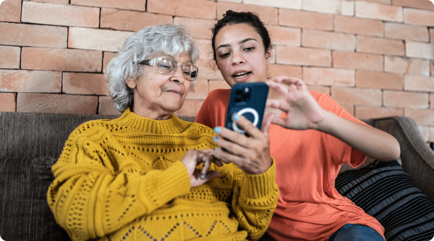 A younger woman and older woman viewing a smartphone together