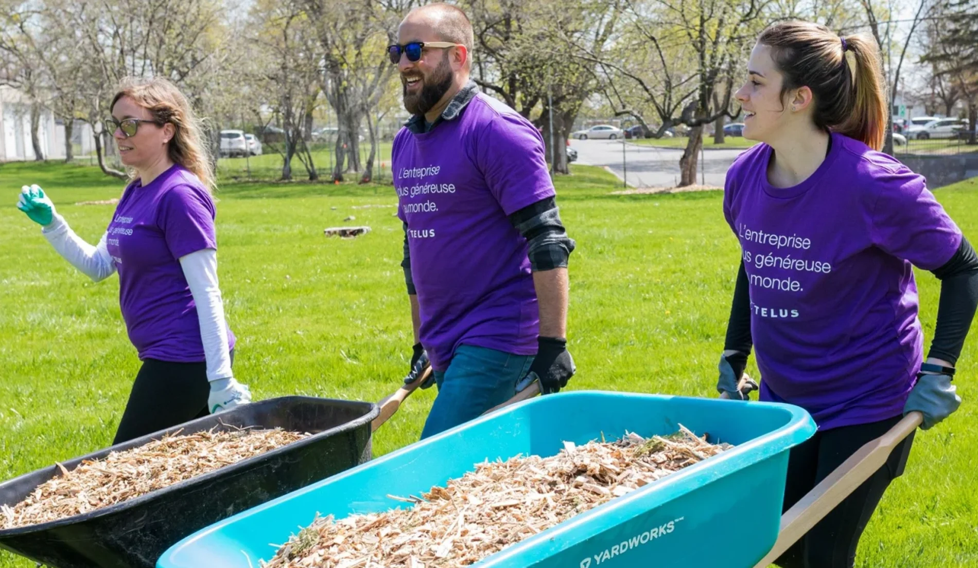 Une image montrant trois employés de TELUS redonnant à la collectivité en aidant à nettoyer le quartier.