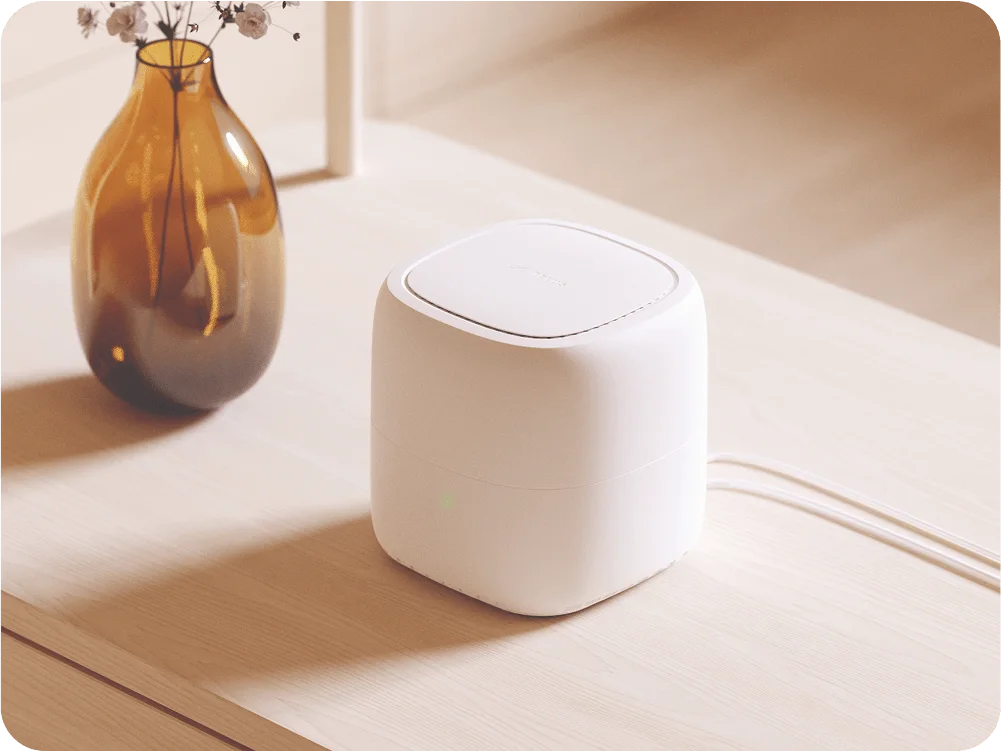 A TELUS modem on a table next to a vase.