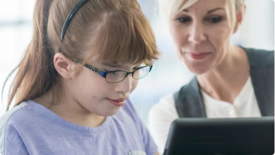 A child and an adult using visual accessibility features on a tablet