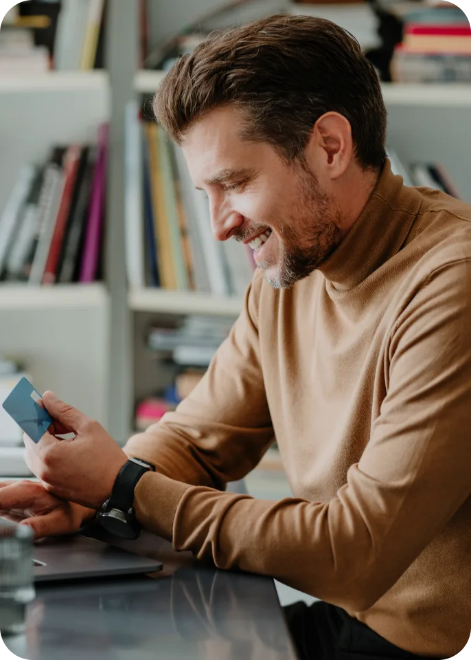 Man reviewing credit card at home office