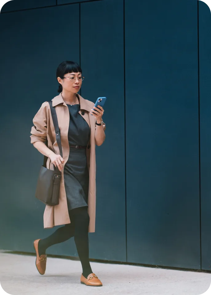 A women outside walking while on her phone