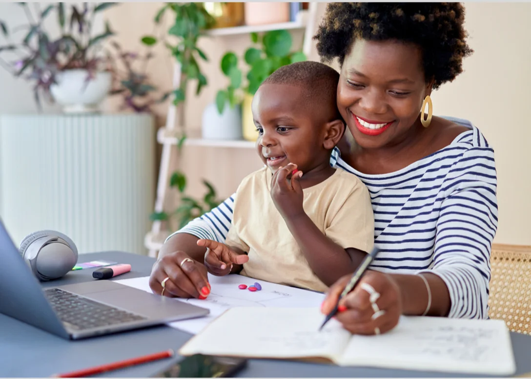 Woman works while her child sits on her lap