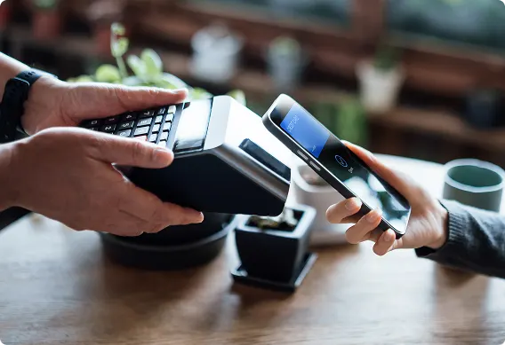 Achat fait par téléphone intelligent à un point de vente, illustrant l’importance cruciale de la conformité à la norme PCI-DSS pour la protection des données de paiement.