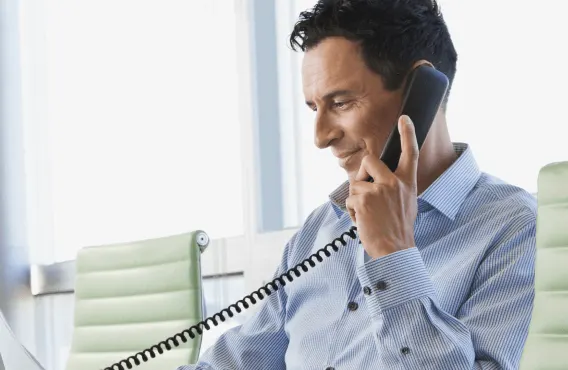 A business professional taking a call in a conference room