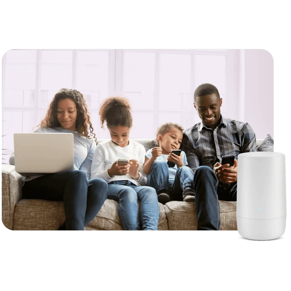 Image of a family of four on a couch browsing on their phones and a laptop