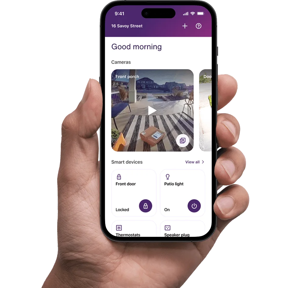 A hand holds a smartphone, displaying a screenshot from the SmartHome+ app