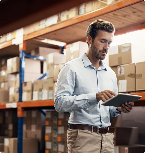 Warehouse manager using tablet for inventory management in distribution center.