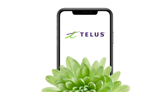 A phone screen displaying the TELUS logo, with a green plant in front of it.