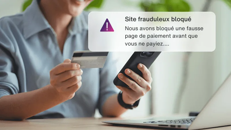 Une femme tenant une carte de crédit et un téléphone près d'un ordinateur portatif, avec une fenêtre qui dit que son numéro de carte est sur le web clandestin.