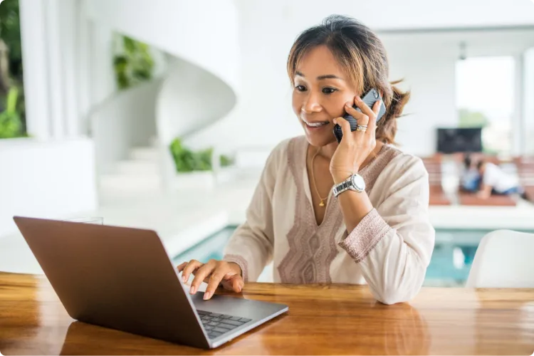 A woman with a laptop speaking on phone