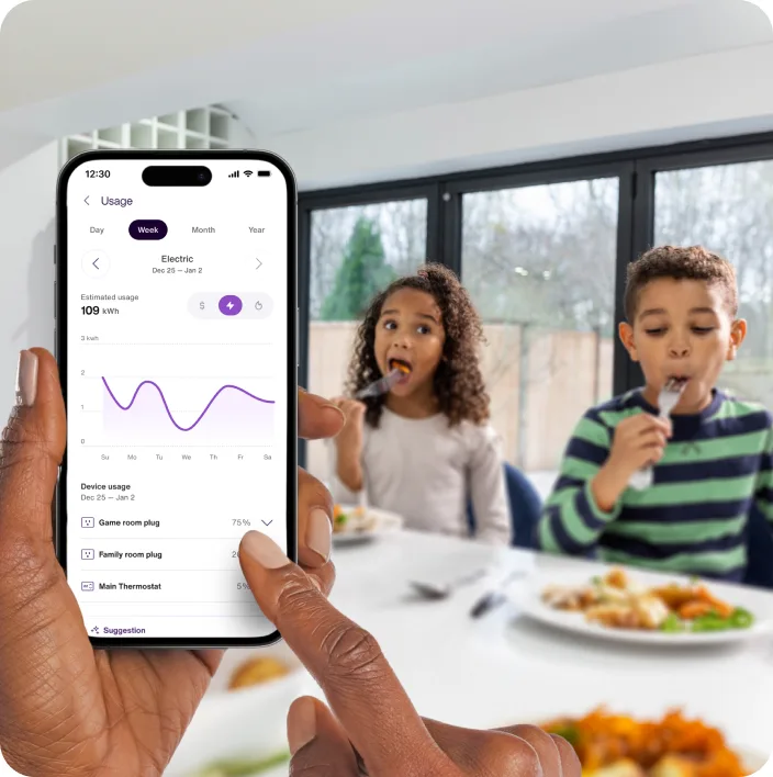 Personne tenant à la main, pendant le petit-déjeuner des enfants, un appareil où sa consommation et ses habitudes en la matière s’affichent dans l’application TELUS MC+. 